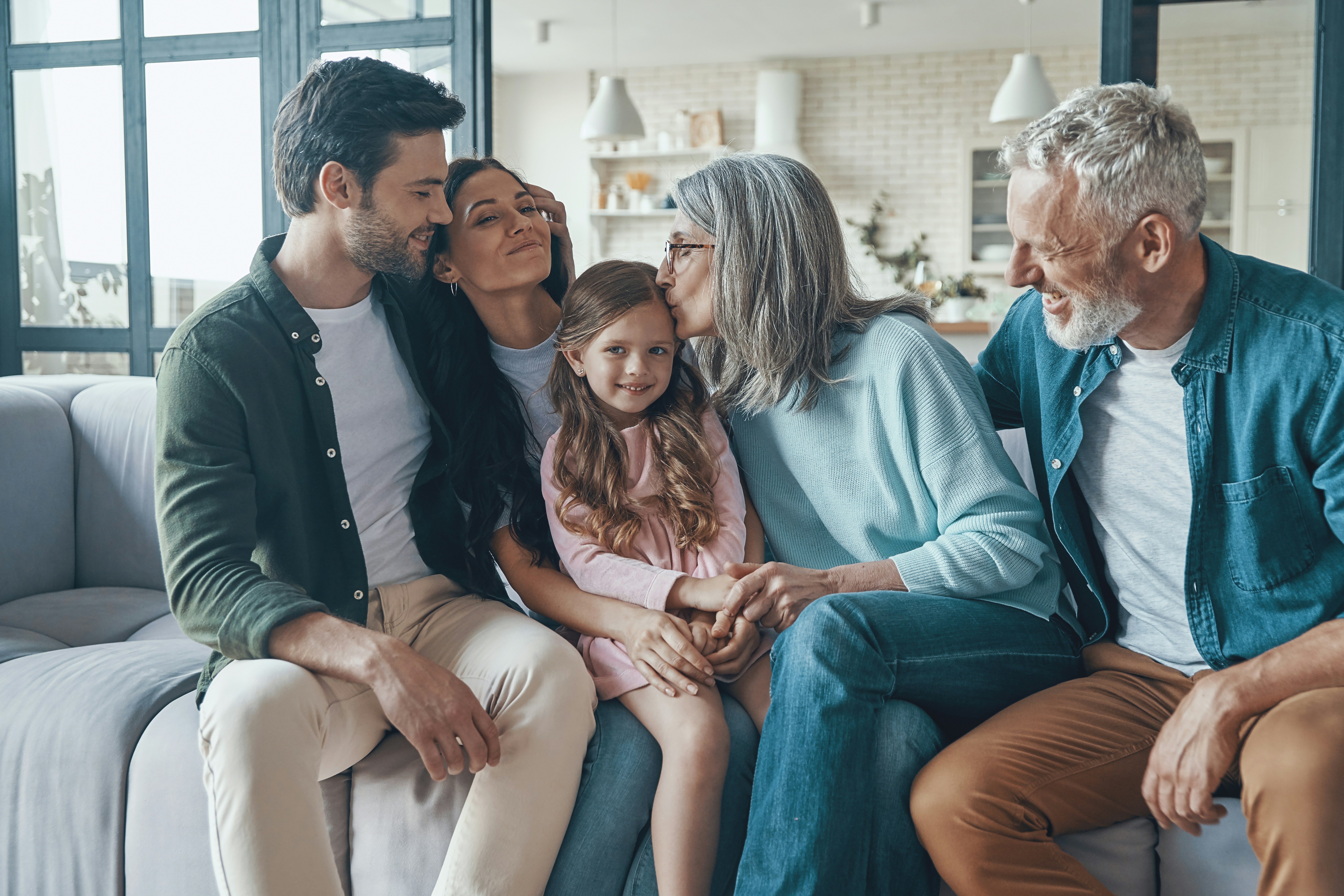 A multigenerational family relaxing together at home, illustrating wealth transfer across generations.