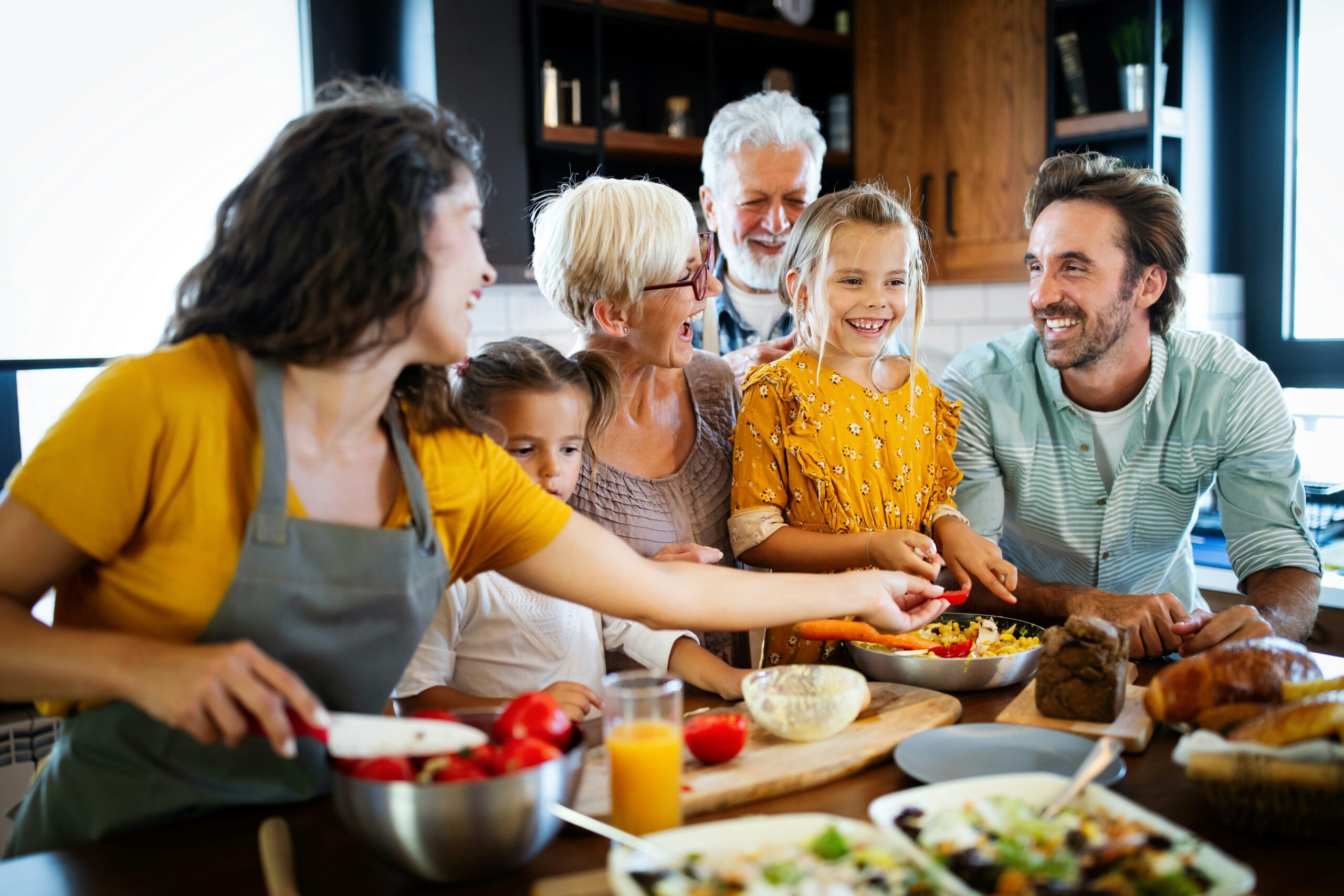 A smiling multi-generational family sitting together on a living room sofa, illustrating family estate and Roth IRA conversion planning.